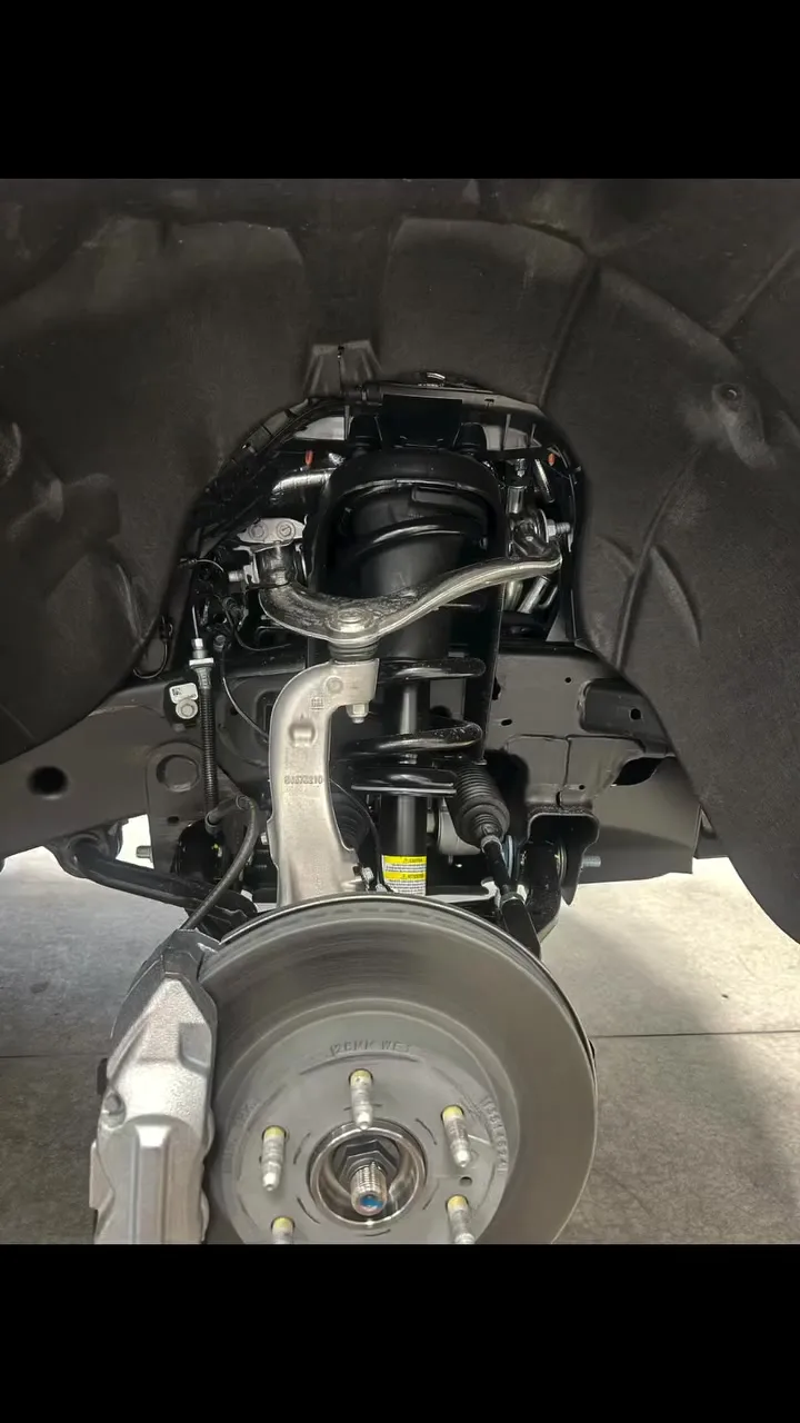 Wheel-off view of clean matte-black Waxoyl protection on a Chevrolet truck